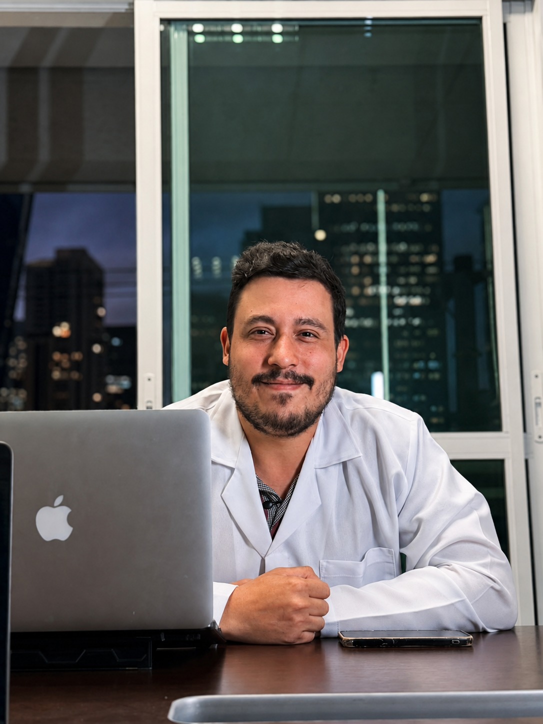 Dr. Dalci Neto, médico responsável pela Clinicanabis, de jaleco, em seu consultório